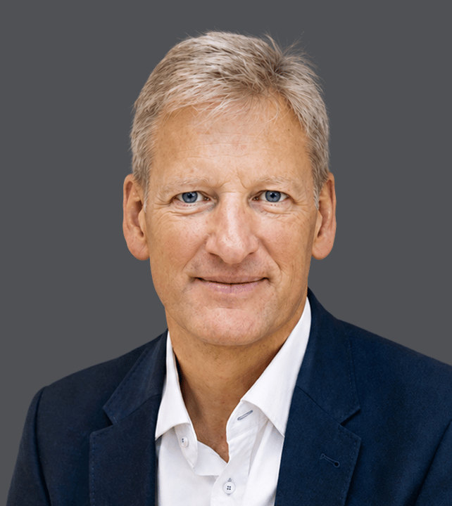 Professional headshot against a neutral background, conveying a confident and approachable demeanor.