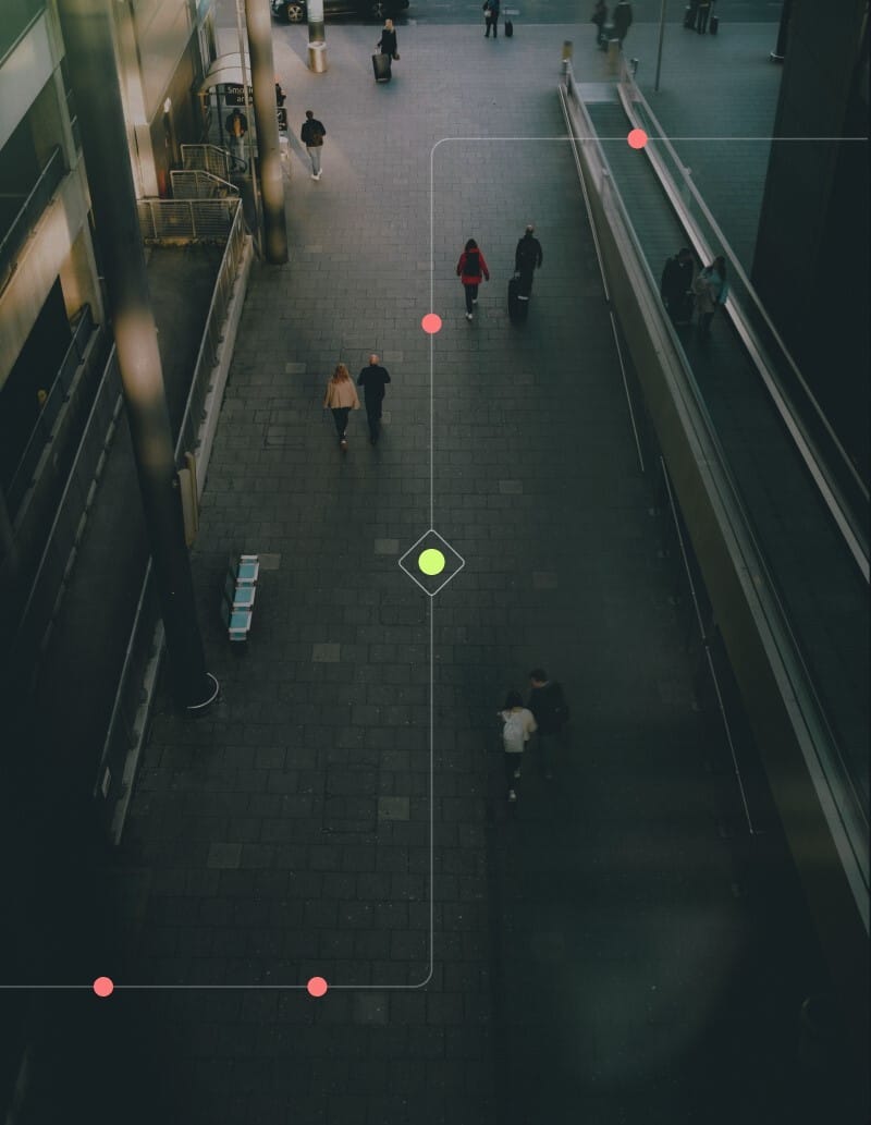 Aerial view of people walking through a modern urban space, with highlighted paths and a central marker on the ground.